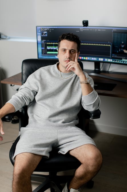 Cardoza poses in an office chair, looking at the camera, his desk and editing equipment behind him