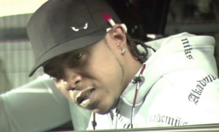 J-Rock wearing a baseball cap and looking out a car window