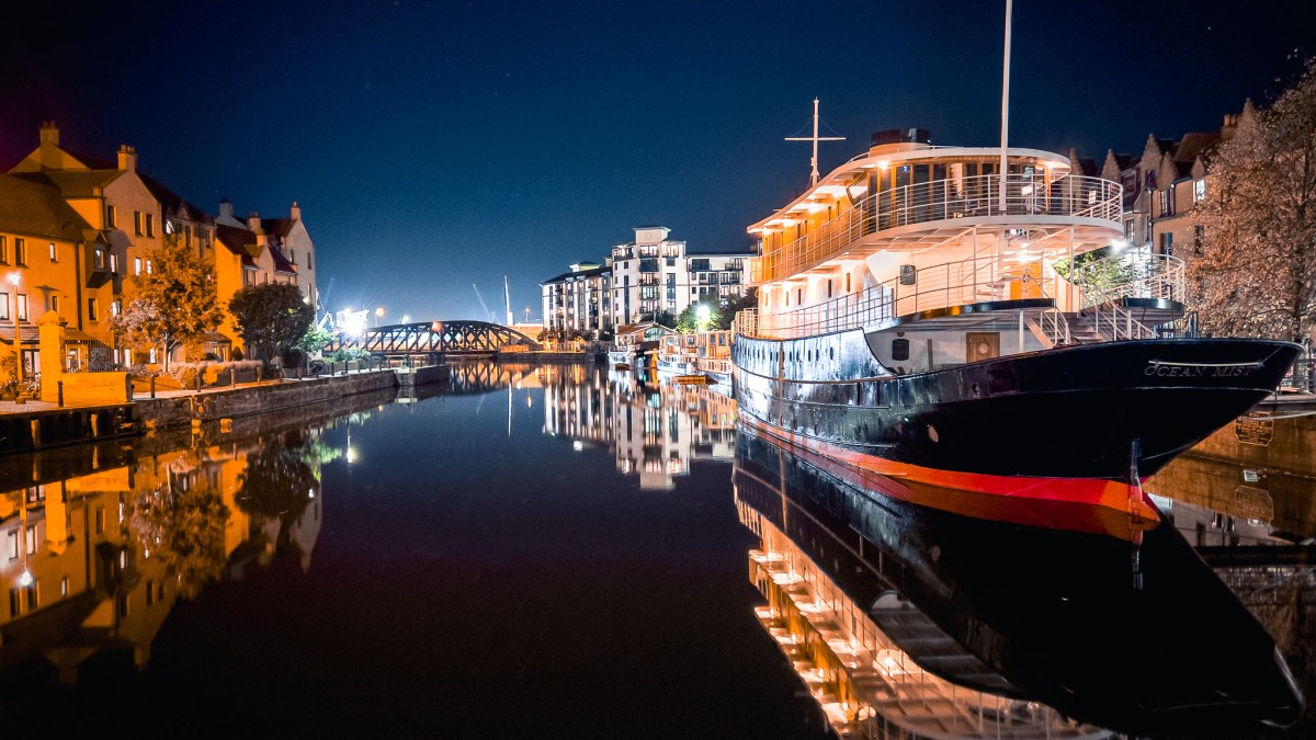 Boats on a quay lit up at night