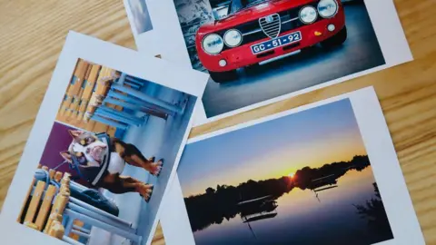 Young at Heart A picture of a dog, a picture of an old red car and a picture of a water scene in Middlesbrough, all placed on a wooden table top.