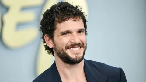 Variety via Getty Images Kit Harrington seen smiling on the red carpet in a blue blazer