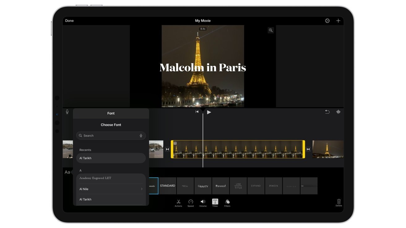 Tablet screen showing a video editing app with a clip of the Eiffel Tower at night titled Malcolm in Paris, timeline below, and font selection menu open on the left
