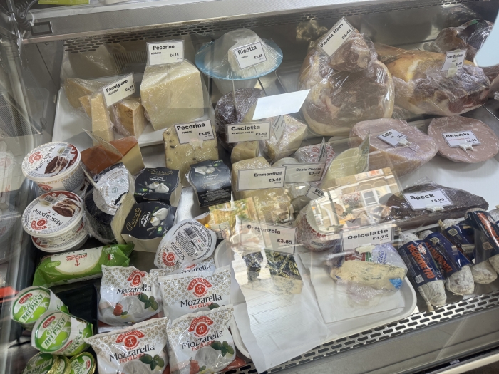 A deli case full of cheeses