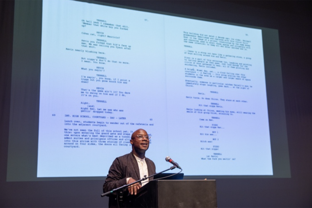 Barry Jenkins at podium in front of projection of a screenplay