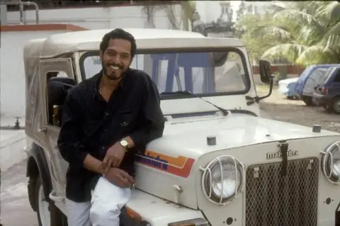 Getty Images An old photo of Nana Patekar standing next to a jeep in Mumbai in a black shirt and white trousers